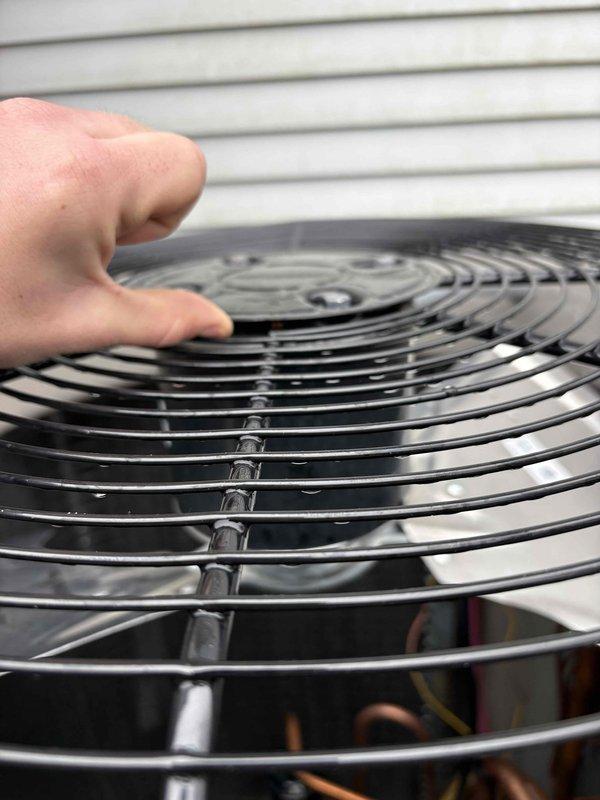 Performed temporary repair on damaged condenser fan shroud assembly. Removed and inspected fan grille, which had become dislodged from mounting points. Secured grille back into position to restore proper airflow protection and prevent debris entry into fan motor assembly until permanent replacement parts can be obtained.