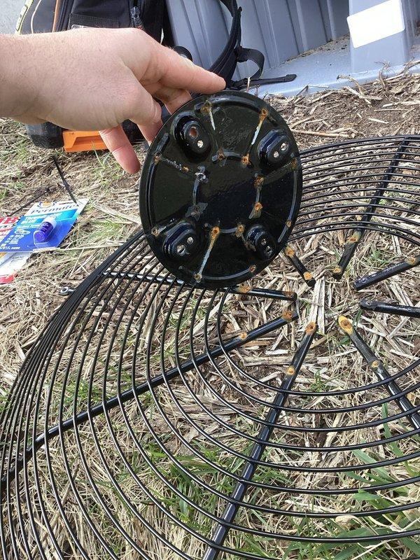 Performed temporary repair on damaged condenser fan shroud assembly. Removed and inspected fan grille, which had become dislodged from mounting points. Secured grille back into position to restore proper airflow protection and prevent debris entry into fan motor assembly until permanent replacement parts can be obtained.