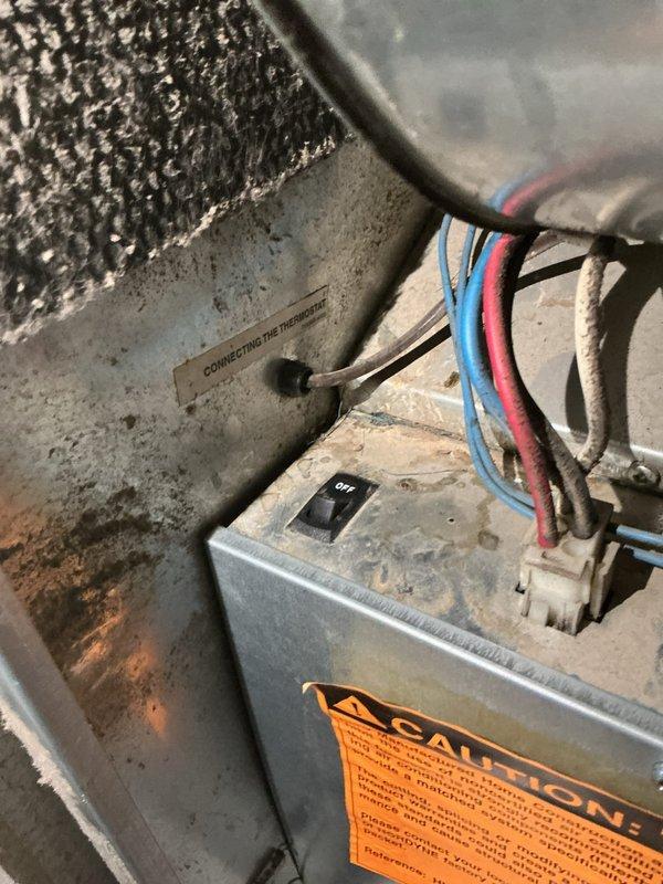 Responded to no-heat call for furnace blowing air but not heating to temperature. Upon inspection, found electrical control components and wiring connections at furnace location. Assessed system operation, documented equipment condition including exterior vent termination showing signs of corrosion and potential exhaust concerns. Captured diagnostic photos of control box wiring and vent pipe condition for service records.