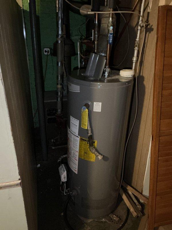 Conducted sales estimate for boiler system replacement following freeze damage to existing heating equipment. Upon inspection, documented damaged boiler and radiator system resulting from frozen pipe conditions. Evaluated water heater installation in utility closet area, noting current plumbing configuration including multiple pipe connections, valves, and safety devices extending from unit to ceiling. Assessed radiator damage in living space where temporary heating equipment had been deployed on concrete subflooring. Photographed existing equipment conditions, plumbing connections, and affected areas to support estimate preparation for complete boiler system replacement and radiator repair or replacement.