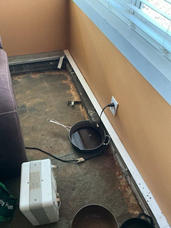 Conducted sales estimate for boiler system replacement following freeze damage to existing heating equipment. Upon inspection, documented damaged boiler and radiator system resulting from frozen pipe conditions. Evaluated water heater installation in utility closet area, noting current plumbing configuration including multiple pipe connections, valves, and safety devices extending from unit to ceiling. Assessed radiator damage in living space where temporary heating equipment had been deployed on concrete subflooring. Photographed existing equipment conditions, plumbing connections, and affected areas to support estimate preparation for complete boiler system replacement and radiator repair or replacement.