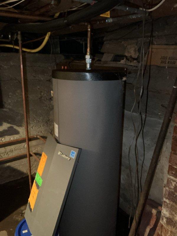 Conducted on-site evaluation of existing boiler system for replacement estimate. Documented current water heater installation with copper piping connections, pressure relief valve, and gas line configuration in basement utility area. Assessed manifold system with five circulator pumps showing significant age-related corrosion and deterioration on copper piping and fittings. Photographed equipment condition and mechanical room layout to develop comprehensive replacement proposal for aging heating distribution system.