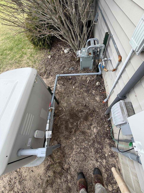 Completed inspection correction by painting exposed gas line piping at exterior meter installation to meet code compliance requirements. Applied appropriate paint coating to gray metal pipes connecting to gas meter assembly, ensuring proper coverage while protecting brass fittings and valves from overspray.