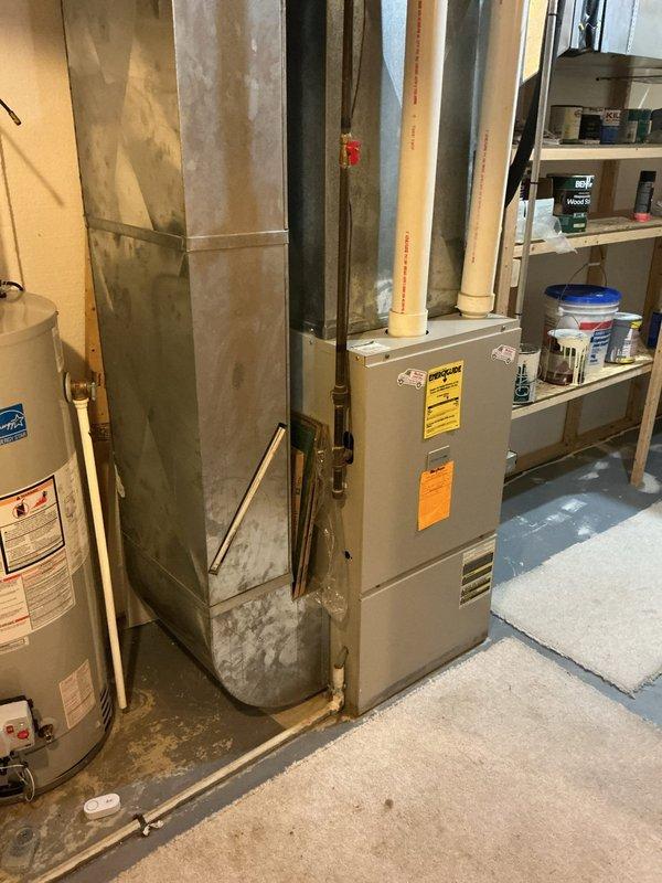 Conducted sales estimate for new air conditioning system replacement at residential property. Assessed existing HVAC setup in basement mechanical room, which currently includes a furnace unit with connected ductwork and water heater. Photographed current equipment configuration, noting the furnace installation with existing metal ductwork distribution system throughout the space. Evaluated the basement utility area layout, including available clearances, electrical service accessibility, and existing HVAC infrastructure to determine optimal placement and specifications for new AC unit installation. Discussed customer requirements and provided professional recommendations for air conditioning system options compatible with current furnace and ductwork configuration.