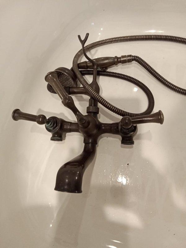 Installed oil-rubbed bronze tub faucet with handheld shower attachment in master bathroom. Verified valve spacing at 7.25" and fixture hole spacing at 7.5" to ensure proper fit. Accessed plumbing through mechanical chase, completed installation of dual-handle faucet assembly with flexible metal hose and showerhead, and tested system for proper operation.