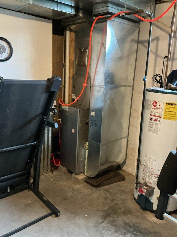 Conducted on-site assessment of existing residential HVAC system in basement mechanical room to provide furnace replacement estimate. Evaluated current gray metal furnace unit, documented equipment specifications, clearances, and existing ductwork configuration, and photographed installation area including adjacent water heater and utility connections to determine replacement requirements and system compatibility.