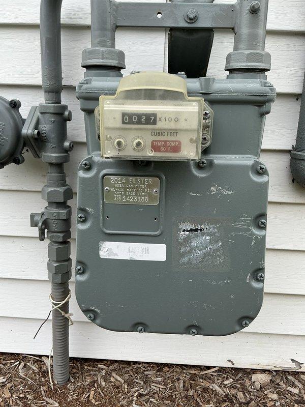 Conducted site assessment for standby generator installation estimate. Documented existing natural gas meter infrastructure, including Elster model gas meter with digital readout and associated piping connections suitable for generator fuel supply. Evaluated electrical service panel configuration, identifying available circuit capacity and load center specifications to determine proper generator sizing and integration requirements for automatic transfer switch installation. Photographed critical components including gas meter assembly with corrugated flex connector and main electrical panel with existing circuit directory to support equipment specifications and installation planning.