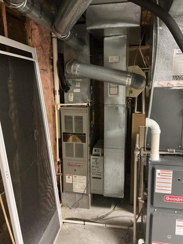 Conducted comprehensive evaluation of existing Goodman furnace and air conditioning system, both approximately 20 years old, to assess condition and provide replacement recommendations. Inspected all HVAC components including furnace unit, ductwork connections, air handler, and associated mechanical systems in basement utility area. Documented equipment specifications, operational status, and installation configuration through detailed photography to support estimate preparation for complete system replacement.