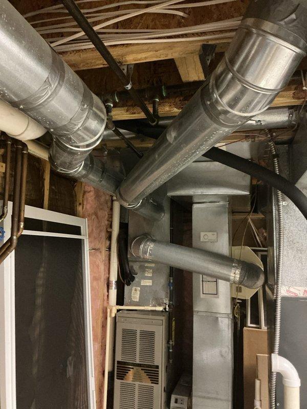 Conducted comprehensive evaluation of existing Goodman furnace and air conditioning system, both approximately 20 years old, to assess condition and provide replacement recommendations. Inspected all HVAC components including furnace unit, ductwork connections, air handler, and associated mechanical systems in basement utility area. Documented equipment specifications, operational status, and installation configuration through detailed photography to support estimate preparation for complete system replacement.