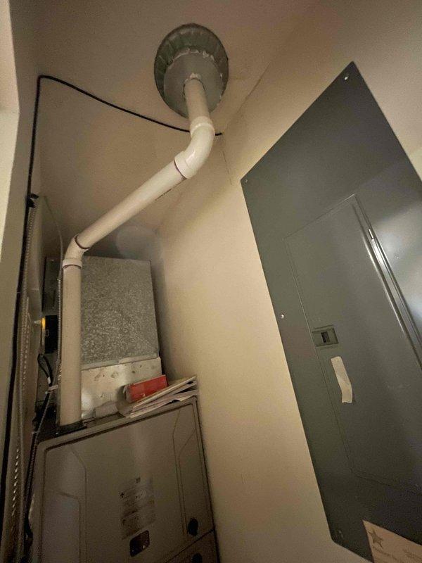 Returned to property to inspect chimney leak reported after winter furnace installation. Accessed roof and installed cap on chimney, then sealed PVC exhaust termination where it penetrates through the chimney structure to prevent water intrusion. Documented mechanical room showing furnace installation with PVC venting system and existing utility equipment for service records.