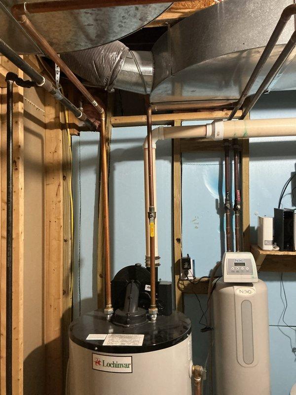 Conducted on-site evaluation of existing 50-gallon Lochinvar water heater in residential basement utility room and provided estimate for upgrading to larger 75-80 gallon capacity unit. Assessed current installation configuration including plumbing connections, gas line accessibility, venting requirements, and available clearances among existing mechanical equipment including water softener system and pressure tank. Documented existing equipment specifications and spatial layout with photographs to determine optimal replacement unit sizing and installation requirements.