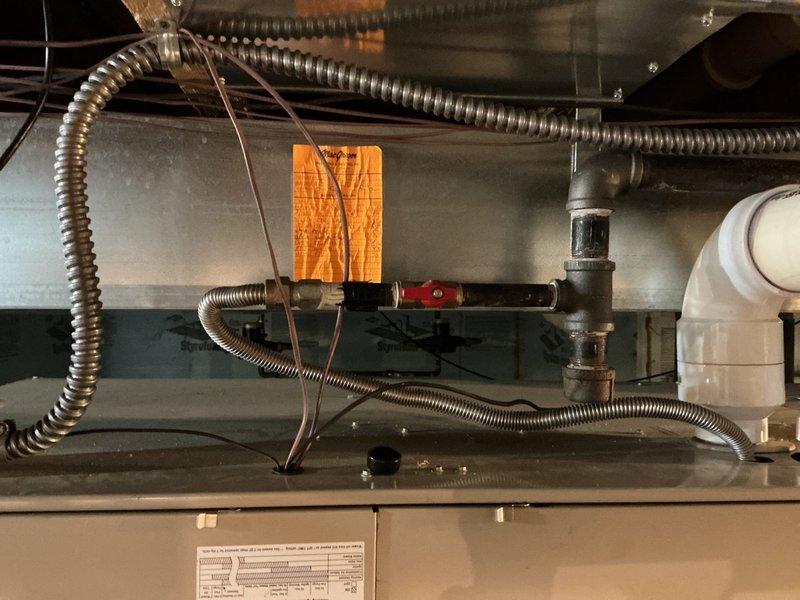 Completed on-site assessment for furnace and air conditioning system replacement estimate. Inspected existing HVAC equipment installation including ductwork, condensate drainage lines, flexible conduits, and electrical connections in mechanical space. Documented current system configuration with photographs showing equipment mounting, PVC drain piping, metallic flex lines, and associated plumbing components to develop comprehensive replacement proposal.