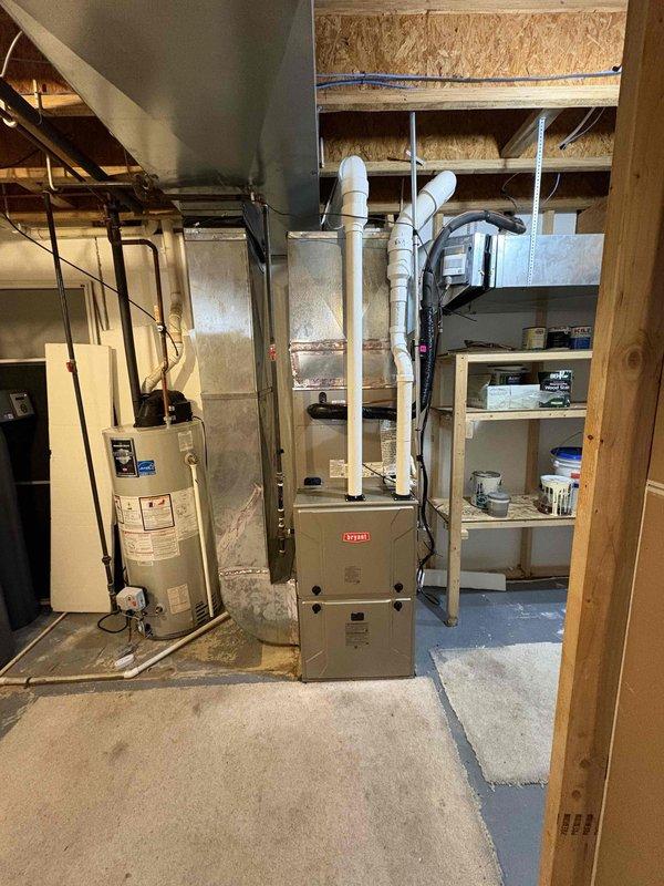 Completed full HVAC system replacement in basement utility area. Removed and disposed of existing furnace and air conditioner unit. Installed new Bryant 2-stage furnace with variable speed ECM blower motor and 14.3 SEER2 condenser unit on outdoor pad. Installation included cased evaporator coil, new line set, and sheet metal transitions. Reconnected gas line, PVC intake and exhaust venting, condensate lines with safety overflow and wet switches, and all electrical connections. Reused existing thermostat. Obtained necessary permits and inspections. System tested and operational.