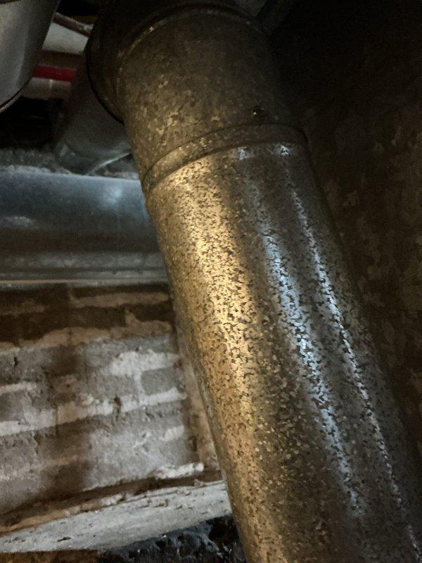 Conducted comprehensive AC estimate for two residential properties. Inspected existing HVAC systems in basement utility areas, documenting aged galvanized ductwork, furnace equipment, and metal supply/return ducts showing significant wear and surface deterioration. Noted extensive condensation on main refrigerant line indicating potential insulation deficiency and temperature differential issues requiring attention during system replacement or upgrade.