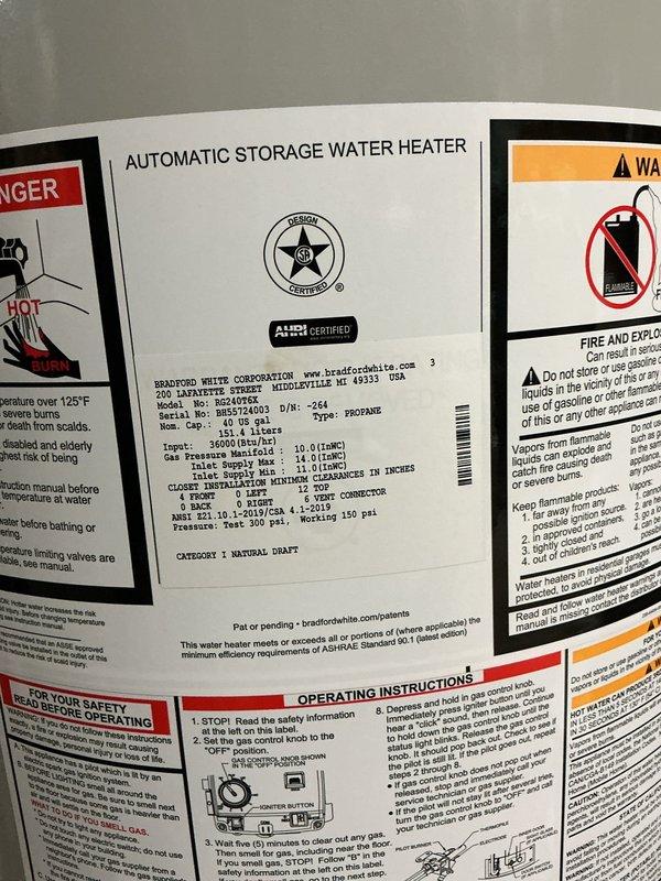 Technician responded to a water heater leak in a residential utility room where two propane water heaters were previously installed in series configuration. The left unit exhibited active leaking from the top connection, causing water accumulation on the concrete floor. After testing the right unit and confirming proper ignition and operation, both existing water heaters were removed and replaced with two Bradford White 40-gallon professional-grade atmospheric vent propane models. The new units were reconfigured from series to parallel plumbing arrangement with individual shut-off valves installed for each water heater, providing independent isolation capability. All copper supply lines were connected with brass compression fittings, and proper venting was established for both units. System was tested, fired successfully, and left in full operational condition with no leaks detected.