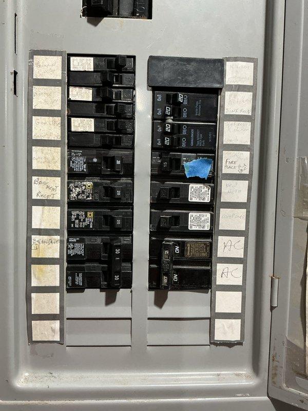 Conducted site assessment for standby generator installation. Evaluated existing electrical service panel containing dual columns of circuit breakers with handwritten circuit identifications. Documented current electrical infrastructure including breaker configuration, panel capacity, and available space for generator integration. Photographed electrical panel to assess compatibility requirements for automatic transfer switch installation and determine proper sizing for backup power system. Reviewed circuit layout including HVAC, fireplace, and other critical loads to establish generator capacity needs and transfer switch specifications for whole-house or essential circuits backup solution.