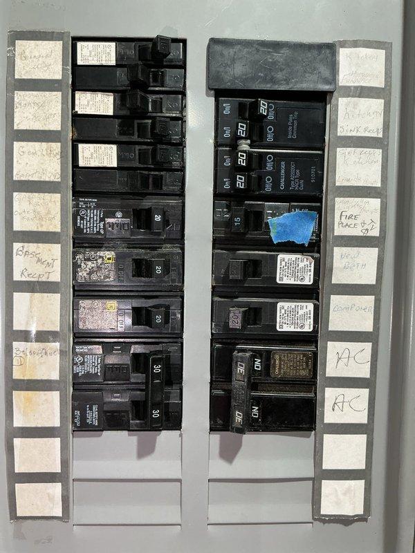 Conducted site assessment for standby generator installation. Evaluated existing electrical service panel containing dual columns of circuit breakers with handwritten circuit identifications. Documented current electrical infrastructure including breaker configuration, panel capacity, and available space for generator integration. Photographed electrical panel to assess compatibility requirements for automatic transfer switch installation and determine proper sizing for backup power system. Reviewed circuit layout including HVAC, fireplace, and other critical loads to establish generator capacity needs and transfer switch specifications for whole-house or essential circuits backup solution.