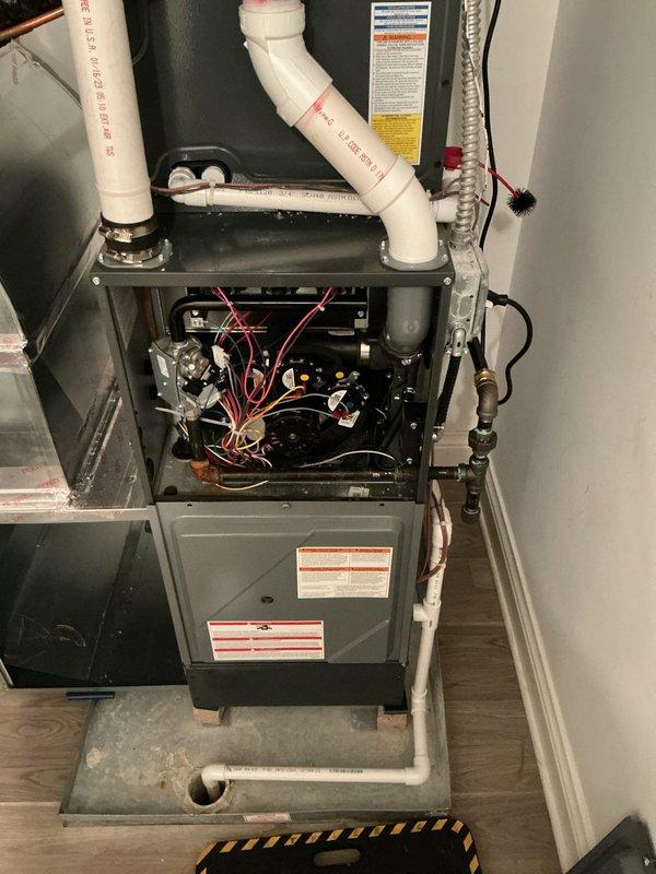 Conducted comprehensive AC system evaluation at residential property. Inspected existing HVAC furnace installation in utility closet, documenting current equipment configuration including gray metal furnace unit with exposed internal components, electrical control boards, and wiring connections. Assessed condition of white PVC condensate drain lines and venting pipes extending from unit top, copper refrigerant lines, and flexible metallic electrical conduit. Examined condensate drain pan with visible residue indicating active use, concrete equipment pad with surface wear, and overall system accessibility. Photographed equipment labels, internal wiring configurations, and component layout to support estimate preparation. Evaluated system for replacement or upgrade recommendations based on current equipment condition and performance requirements.