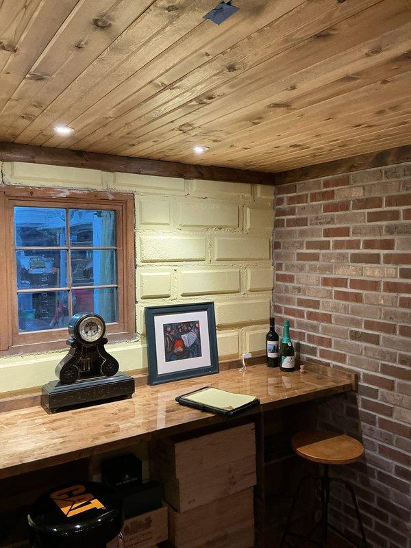 Completed sales estimate for new wine cellar cooling system installation in residential basement space featuring exposed brick walls, wood plank ceiling, and rustic interior finishes. Assessed room dimensions, existing electrical infrastructure, and ventilation requirements to determine appropriate equipment sizing and installation approach. Documented space conditions through photographs and provided customer with detailed proposal for dedicated cooling unit to maintain proper temperature and humidity control for wine storage.