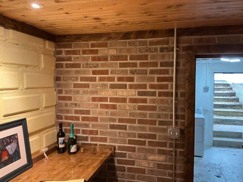 Completed sales estimate for new wine cellar cooling system installation in residential basement space featuring exposed brick walls, wood plank ceiling, and rustic interior finishes. Assessed room dimensions, existing electrical infrastructure, and ventilation requirements to determine appropriate equipment sizing and installation approach. Documented space conditions through photographs and provided customer with detailed proposal for dedicated cooling unit to maintain proper temperature and humidity control for wine storage.