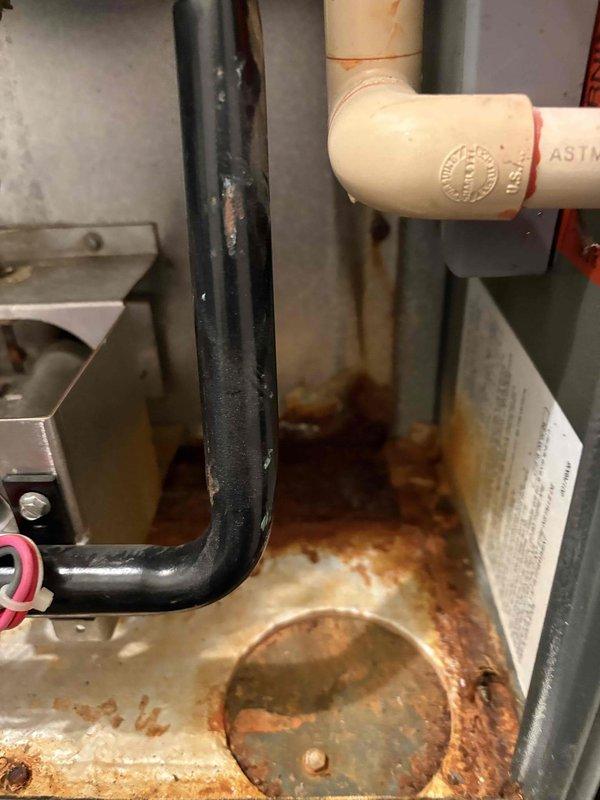 Responded to a no cooling complaint on a 15-year-old air conditioning system. Upon inspection, discovered severely corroded condensate drain pan and extensive rust throughout the evaporator coil assembly, indicating prolonged moisture exposure and deterioration of critical components. System was diagnosed as unable to maintain proper cooling due to compromised heat exchange efficiency from corroded surfaces and potential refrigerant pathway restrictions, requiring system replacement rather than standard tune-up service.