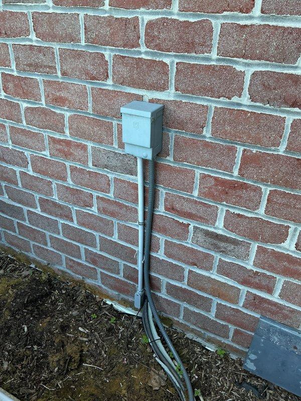 Conducted on-site evaluation of aging air conditioning system requiring obsolete refrigerant type. Assessed existing outdoor condensing unit mounted on concrete pad against exterior brick wall, noting weathered refrigerant lines and electrical conduit routing. Documented current equipment configuration and discussed replacement options with modern, code-compliant system utilizing current-generation refrigerant. Provided comprehensive HVAC replacement estimate for updated equipment installation.