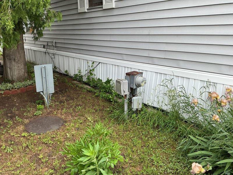 Conducted on-site assessment for furnace and air conditioning system replacement at mobile home property. Evaluated existing electrical service panel and outdoor utility connections to determine compatibility and capacity requirements for new HVAC equipment installation. Documented current electrical infrastructure including main service disconnect, circuit breaker configuration, and exterior meter location to ensure proper sizing and compliance for proposed heating and cooling system upgrade.