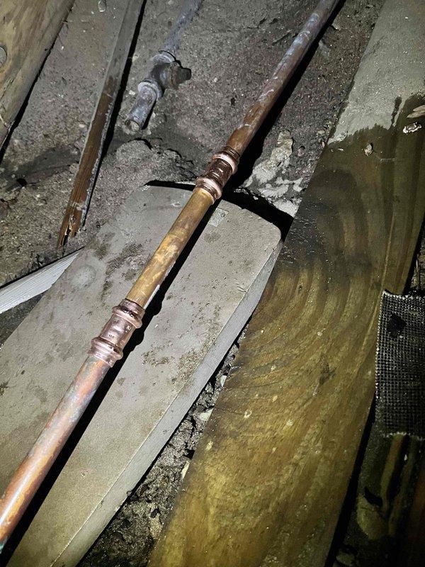 Responded to no-water emergency call due to pipe break in crawl space. Located failed section of copper water line with active leak causing service interruption. Temporarily repaired compromised pipe section with multiple layers of professional-grade repair tape to restore water service. Inspected surrounding copper piping system, noting age-related corrosion, patina buildup, and oxidation on pipes and compression fittings throughout the area. Documented existing conditions including greenish discoloration on copper components and general system deterioration. Restoration of water service confirmed upon completion of emergency repair.