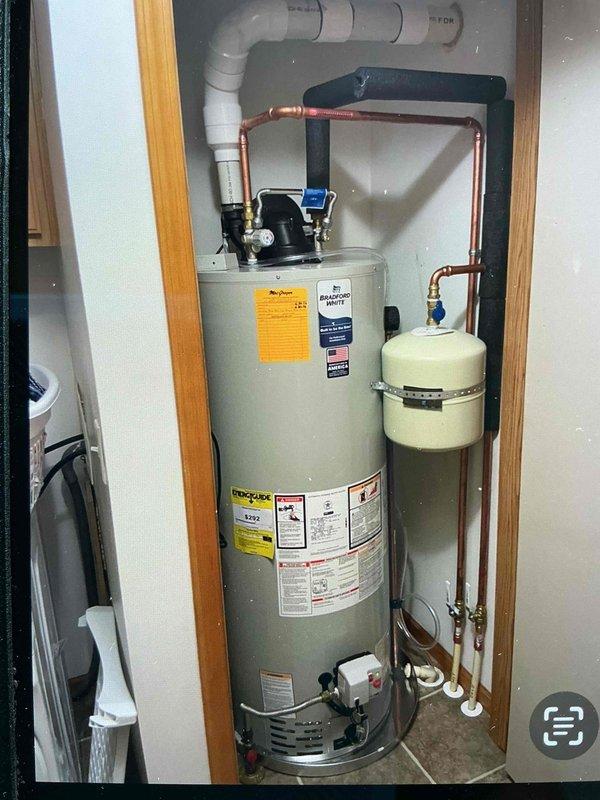 Replaced existing water heater with new 50-gallon power vent natural gas unit, including installation of expansion tank, copper supply lines with shut-off valves, and recirculation pump. Additionally installed new PVC combustion air intake piping for existing furnace, with exterior termination through building siding.