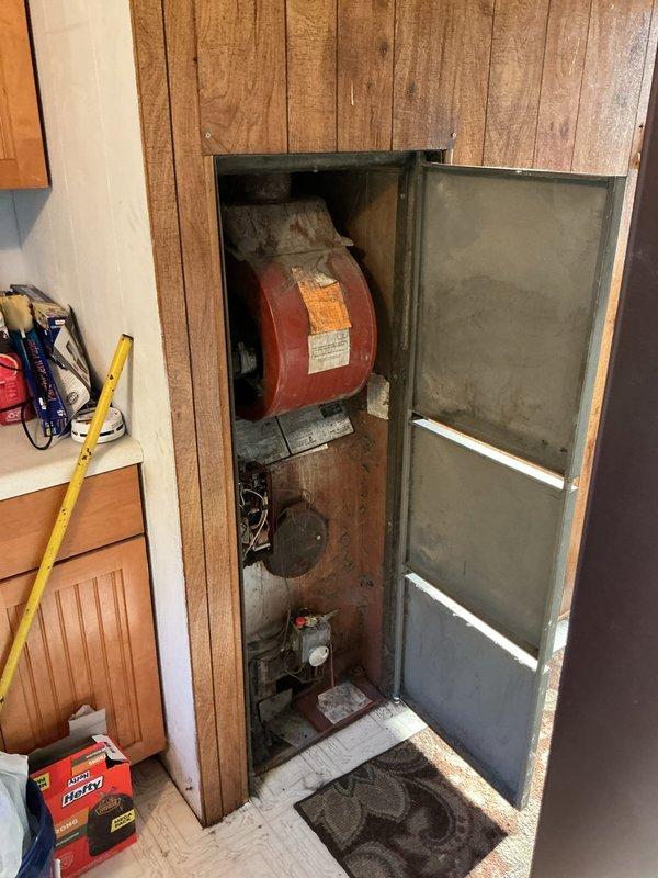 Conducted on-site assessment for furnace and air conditioning system replacement. Evaluated existing 30-year-old furnace located in utility closet, documenting equipment condition, installation configuration, and mechanical connections. Photographed current system layout including gas meter, piping infrastructure, and existing thermostat with dual-scale temperature display. Gathered measurements and specifications necessary to provide comprehensive estimate for new HVAC equipment installation. Assessed utility closet dimensions and access constraints for future equipment replacement planning.