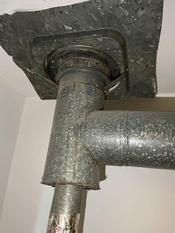 Conducted sales estimate for boiler replacement in residential property. Documented existing aged heating equipment showing significant wear, deterioration, and accumulated debris on metal surfaces and components with visible BTU rating plates. Assessed ductwork system including ceiling-mounted flexible metallic ducting with mounting flanges and evaluated overall HVAC infrastructure condition to provide comprehensive replacement recommendations.