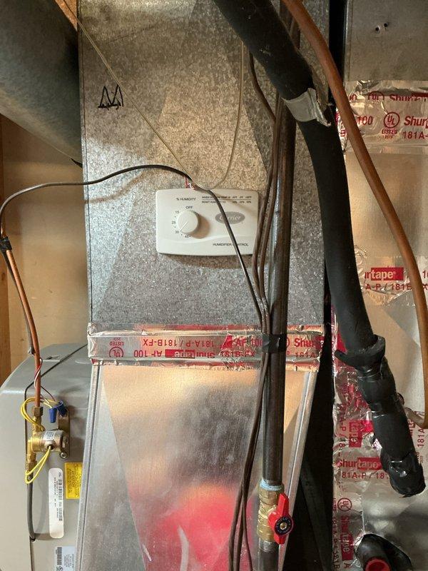 Conducted sales estimate for 2-ton air conditioning system replacement. Evaluated existing outdoor cylindrical condenser unit with silver metallic finish located in side yard on concrete pad, noting existing electrical and refrigerant line conduits running along exterior wall. Inspected indoor air handler unit installed in attic space, assessing copper refrigerant lines, existing ductwork connections, and electrical wiring. Documented current system configuration and provided replacement options for complete HVAC system upgrade.