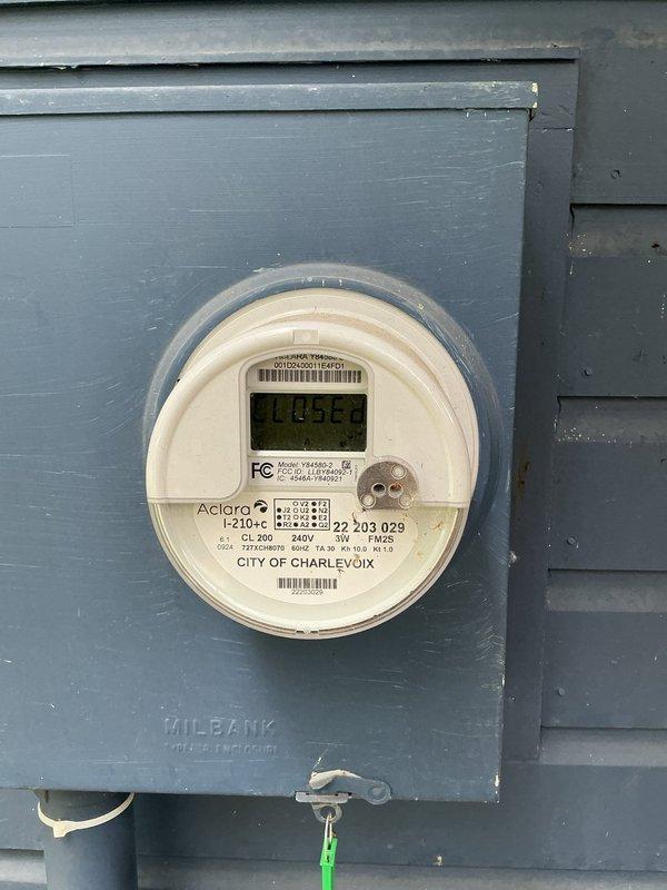 Conducted comprehensive estimate for complete HVAC system conversion from all-electric split system to heat pump with gas backup capability. Property currently equipped with electric radiant baseboard heaters in individual rooms with separate thermostats and central forced air air conditioning only. Evaluated existing electrical service panel showing adequate breaker capacity and reviewed digital utility meter installation on exterior. Assessed feasibility of full heat pump conversion including replacement of outdoor condenser unit and indoor air handler while retaining existing baseboard heaters as supplemental heat source. Documented requirement for new gas line installation from utility provider to enable future gas heating option, noting entire residence currently operates on electric service. Photographed electrical infrastructure including main distribution panel with available breaker slots and exterior meter base configuration to support system upgrade planning and load calcula