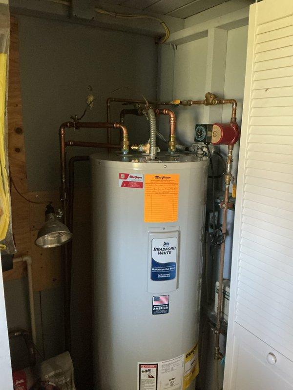Installed Bradford White water heater in basement utility area with difficult access requiring two-person crew. Completed all copper piping connections, installed expansion tank, and ensured proper pressure relief valve configuration. Addressed customer questions regarding electrical grounding requirements following recent well installation.