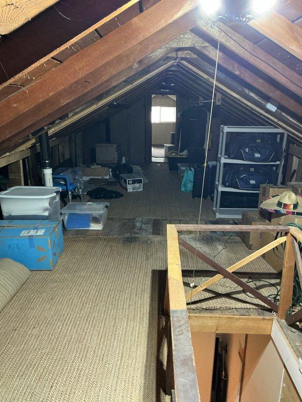 Conducted site assessment for new high velocity HVAC system installation in older home without existing high velocity equipment. Inspected attic space to evaluate structural conditions, available routing pathways, and installation feasibility for compact ductwork and air handler placement. Documented existing attic configuration including storage layout, framing structure, access points, and observed what appears to be current HVAC components including flexible ductwork and mechanical equipment mounted on support framework. Photographed attic conditions to support system design and provide accurate quote for complete high velocity system installation.