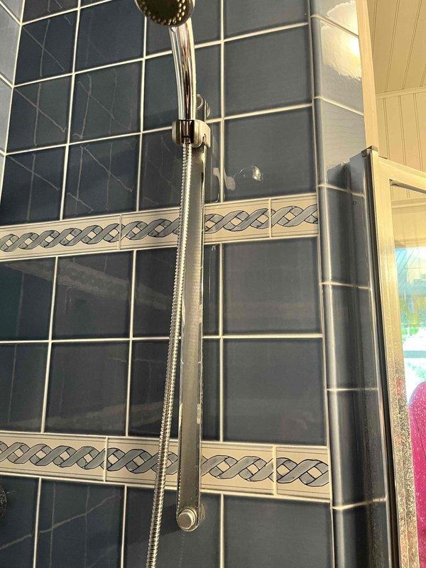 Responded to service call for multiple plumbing issues including master bathroom lacking hot water, disconnected refrigerator water line, and washing machine water supply problem. Inspected shower fixtures and valve assembly in master bathroom, documented existing conditions and mineral buildup on fixtures. Addressed water supply concerns and restored proper water flow to affected areas.