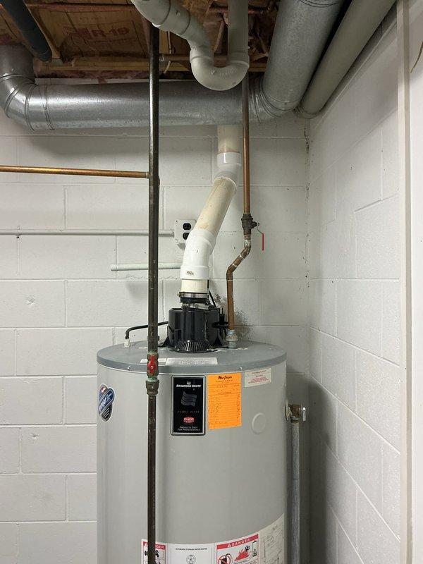 Provided estimate for replacement of 21-year-old water heater in basement utility room. Assessed existing unit with standard top-mounted connections including PVC exhaust venting, copper supply lines, and associated plumbing infrastructure. Documented current installation configuration alongside furnace and water softener equipment for replacement planning.