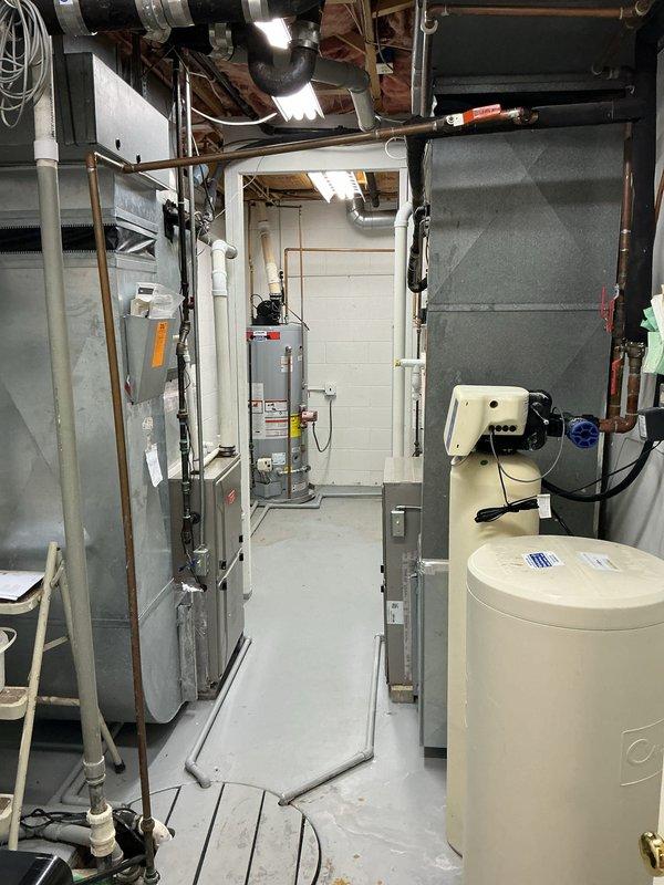 Provided estimate for replacement of 21-year-old water heater in basement utility room. Assessed existing unit with standard top-mounted connections including PVC exhaust venting, copper supply lines, and associated plumbing infrastructure. Documented current installation configuration alongside furnace and water softener equipment for replacement planning.