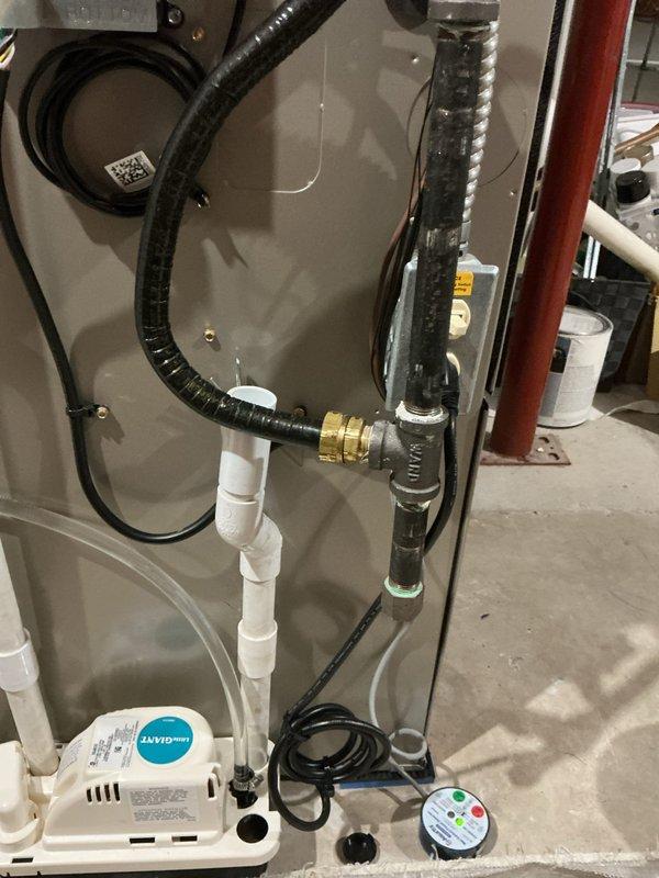 Installed new condensate pump with discharge line routed to P-trap for Bryant furnace system. Secured all PVC piping and electrical connections, verified proper pump operation and drainage flow.