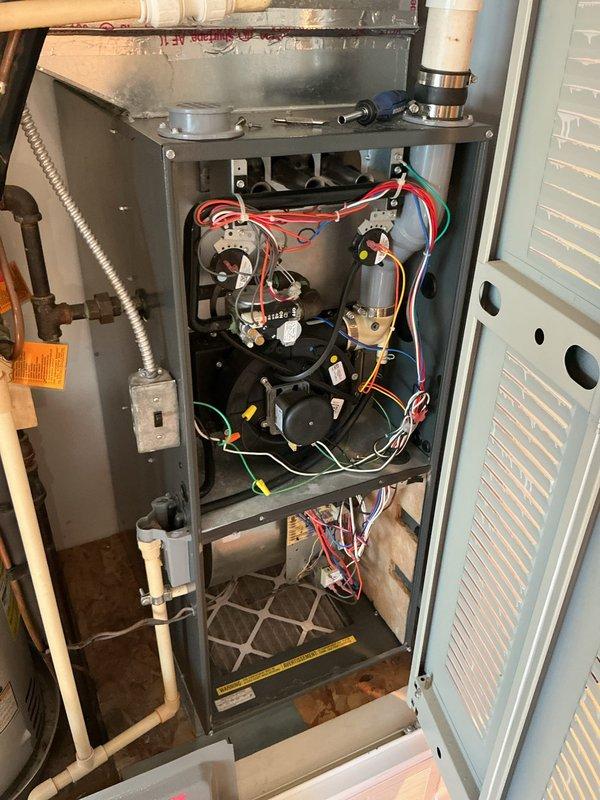 Performed comprehensive furnace system evaluation for home warranty estimate. Documented existing HVAC installation including Emerson control board, gas valve assembly, blower motor components, electrical wiring configurations, PVC venting and condensate drain lines, and filtration system. Captured detailed photographs of internal components with access panel removed to assess overall system condition and operational status for estimate preparation.
