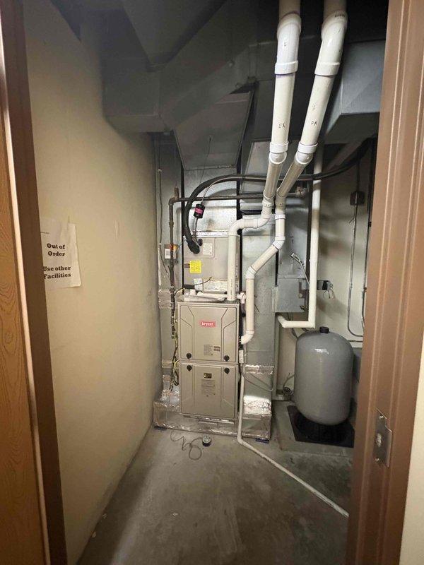 Completed removal and disposal of existing 2-ton air conditioning system including condenser unit and pad. Installed new Bryant HVAC system consisting of furnace with drain pan and 2-ton Puron condenser unit on concrete pad. New equipment positioned on exterior concrete pad with proper electrical disconnect and conduit installation, while furnace installed in mechanical room with PVC venting routed through ceiling and connected to existing ductwork.