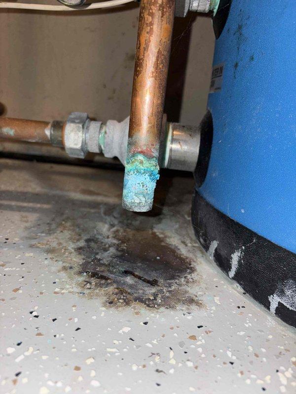 Completed annual cooling maintenance on two heat pump systems with six indoor heads, performing comprehensive tune-up procedures including filter inspection, coil cleaning, refrigerant level verification, and electrical connection checks. Conducted leak search using previously installed UV dye tracer; inspected all refrigerant lines, connections, and components with UV light to identify potential leak sources. Documented plumbing infrastructure conditions during inspection, noting copper pipe corrosion with verdigris buildup at fittings and water heater installation with properly configured temperature and pressure relief valve and discharge piping.