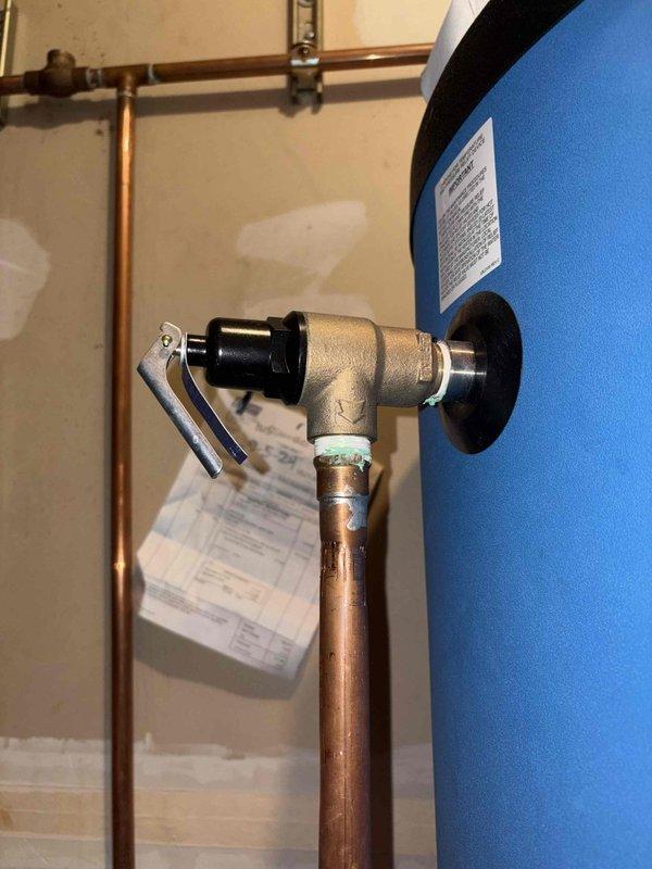 Completed annual cooling maintenance on two heat pump systems with six indoor heads, performing comprehensive tune-up procedures including filter inspection, coil cleaning, refrigerant level verification, and electrical connection checks. Conducted leak search using previously installed UV dye tracer; inspected all refrigerant lines, connections, and components with UV light to identify potential leak sources. Documented plumbing infrastructure conditions during inspection, noting copper pipe corrosion with verdigris buildup at fittings and water heater installation with properly configured temperature and pressure relief valve and discharge piping.