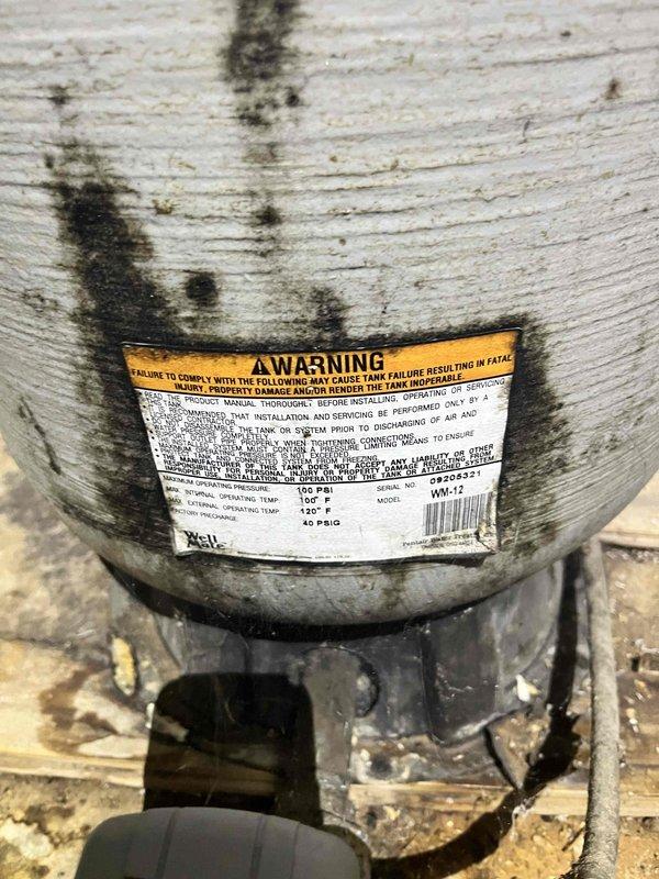 Conducted on-site assessment for water heater replacement estimate along with water softener installation including shut-off valves for both units. Inspected existing water heater showing significant age-related deterioration with extensive staining and discoloration on exterior surfaces, indicating prolonged exposure to moisture and environmental conditions. Documented current equipment specifications from manufacturer labels including temperature ratings and model information. Photographed installation area showing wooden platform base and existing plumbing connections in unfinished utility space. Evaluated space requirements and existing infrastructure for proposed water heater and softener system installations with appropriate isolation valves for future maintenance accessibility.