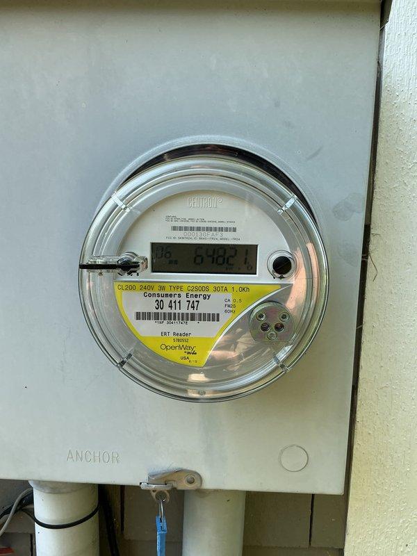 Conducted on-site assessment for standby generator installation at residential property. Documented existing electrical service configuration, including 200-amp 240V 3-wire Centron meter with Consumers Energy service, and photographed exterior mounting locations on home with mixed siding materials to determine optimal generator placement and electrical connection requirements.