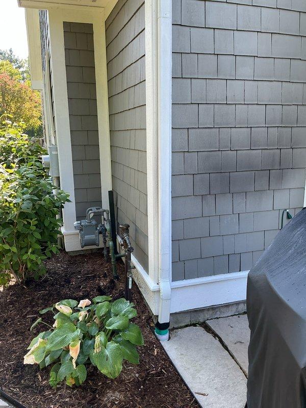 Conducted on-site assessment for standby generator installation at residential property. Documented existing electrical service configuration, including 200-amp 240V 3-wire Centron meter with Consumers Energy service, and photographed exterior mounting locations on home with mixed siding materials to determine optimal generator placement and electrical connection requirements.