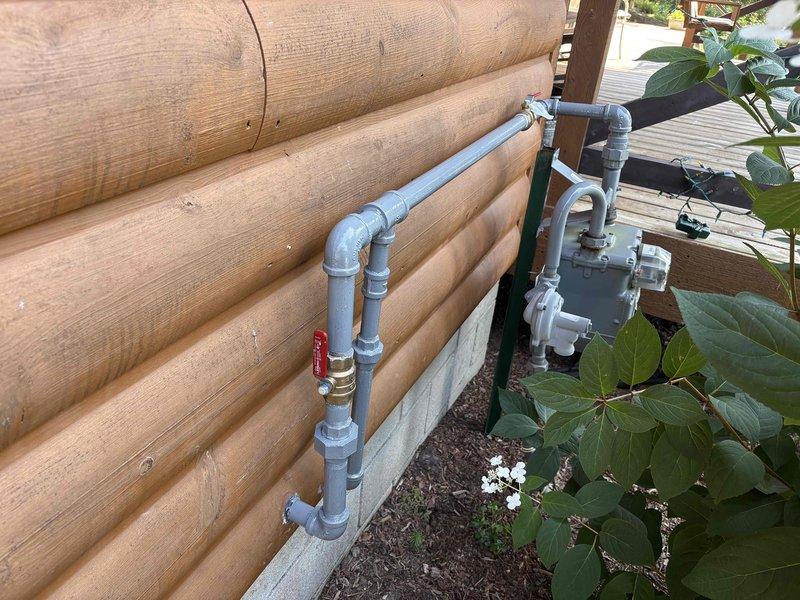 Corrected inspector-identified deficiencies on exterior plumbing system by applying corrosion-resistant coating to exposed metallic piping and fittings, and installed proper support brackets to secure unsupported pipe sections in accordance with code requirements.