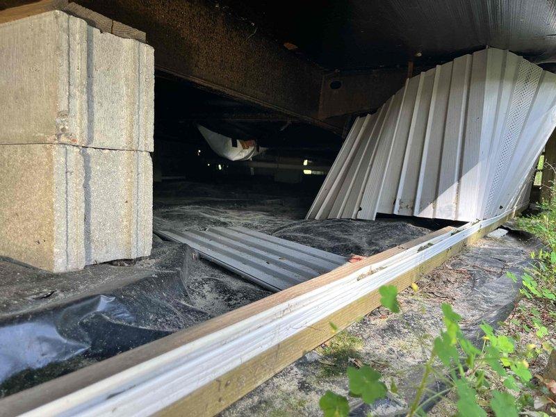 Responded to water leak service call for mobile home with three separate leak locations identified in crawlspace area. Inspected and addressed leak at north end bathroom, leak under kitchen sink, and intermediate leak between bathroom and kitchen areas. Repaired valve that was spraying water when water pump activated. Accessed crawlspace beneath structure to locate and repair all three leak points, documented conditions with photos showing foundation area and plumbing infrastructure.