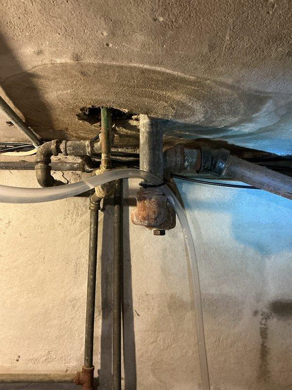 Conducted inspection of residential plumbing system to assess repairs needed for upstairs bathtub trap replacement, laundry sink hookup, and non-functioning faucet replacement. Photographed existing plumbing infrastructure including corroded pipes, aged fittings, and water heater connections showing significant oxidation and wear. Prepared documentation for quote preparation on requested plumbing repairs to support grant-funded home improvement project.