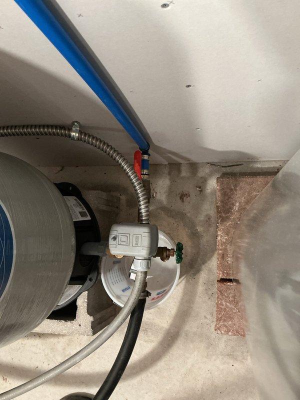 Conducted on-site assessment for whole-home water filtration or treatment system installation. Evaluated existing plumbing infrastructure including water heater connections, supply lines, and available installation space in utility area. Documented current system configuration with brass fittings, flexible supply lines, and PEX piping. Observed evidence of previous water staining on concrete floor near water heater base, indicating potential water quality concerns that support need for filtration system. Photographed existing plumbing layout and connection points to develop comprehensive quote for recommended water treatment solution.